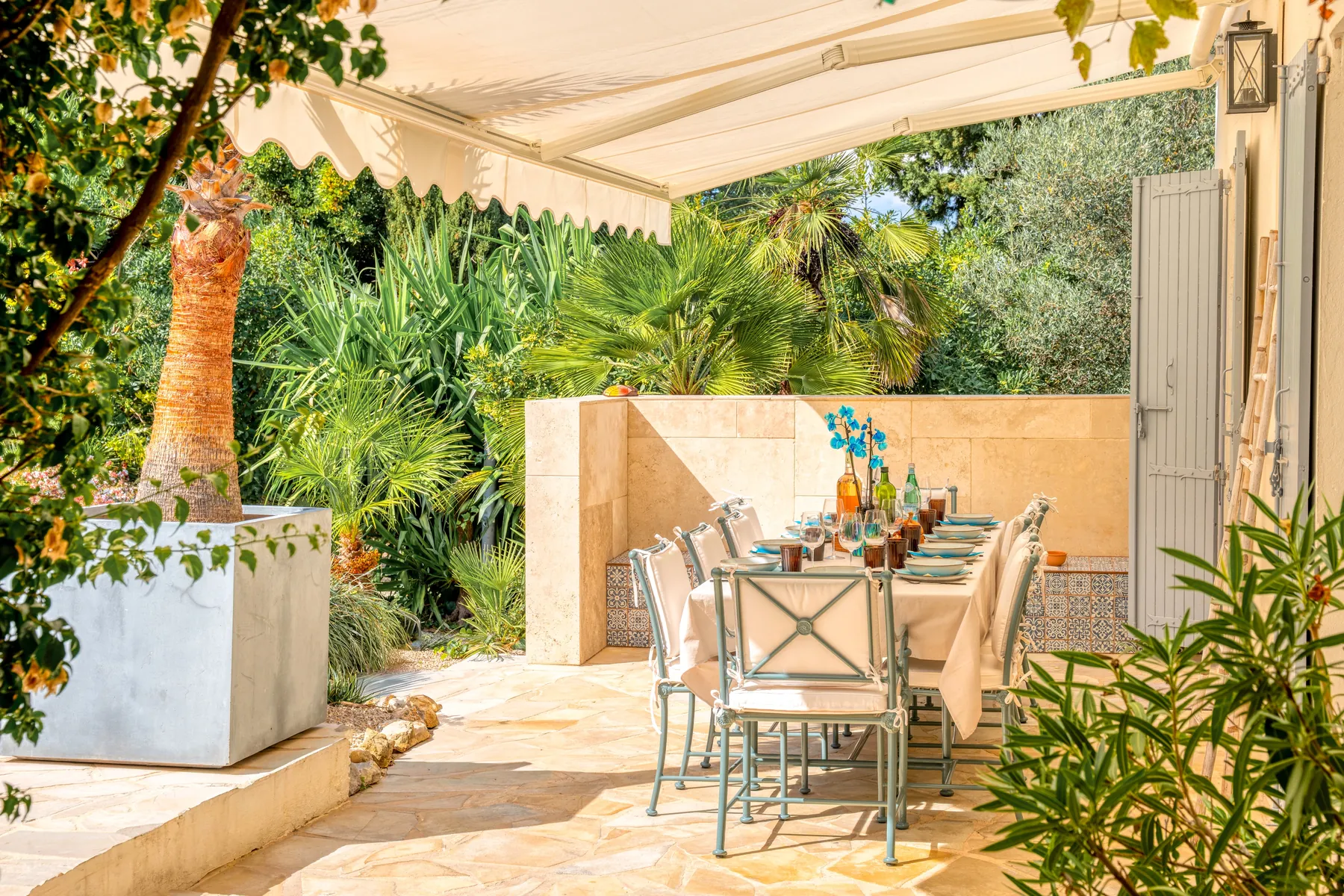An intimate outdoor table beneath a shaded terrace