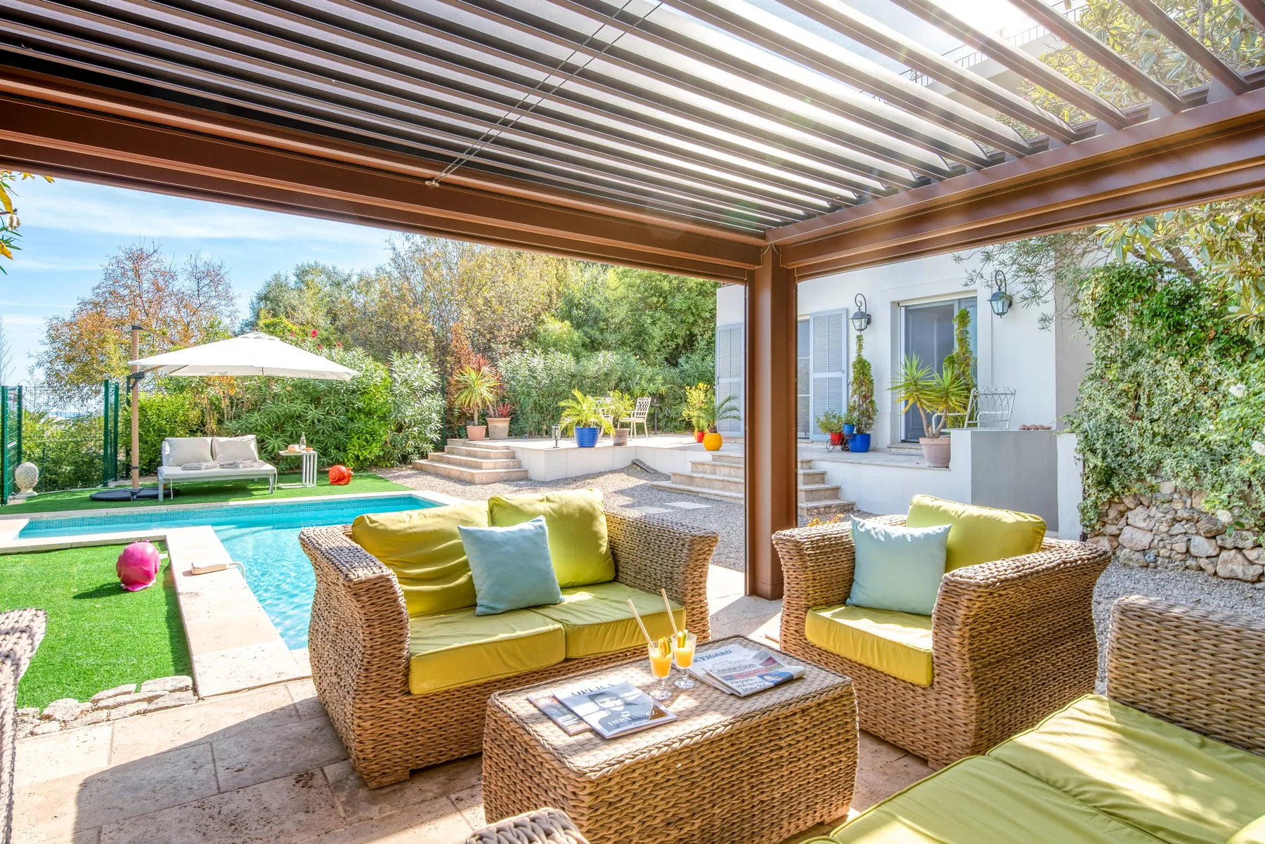Covered seating area opening directly onto a pool terrace