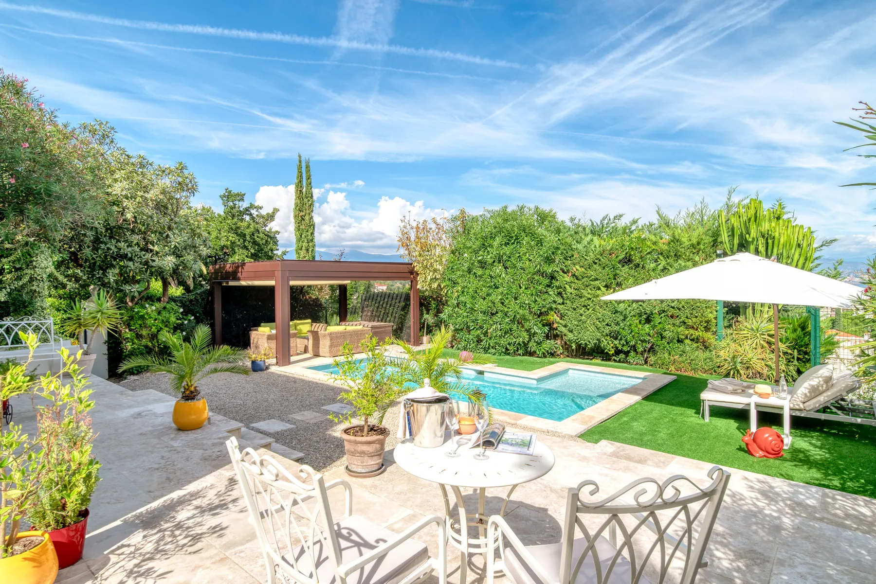 Pool terrace with loungers, parasol and Mediterranean planting