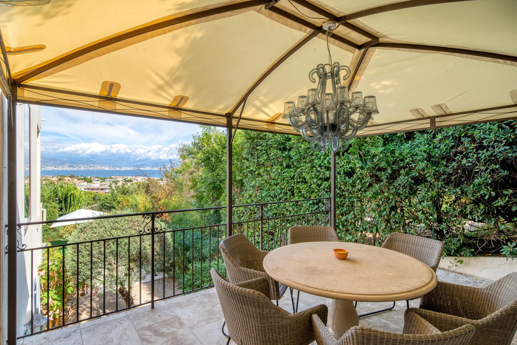 Covered balcony with a round table and Mediterranean view
