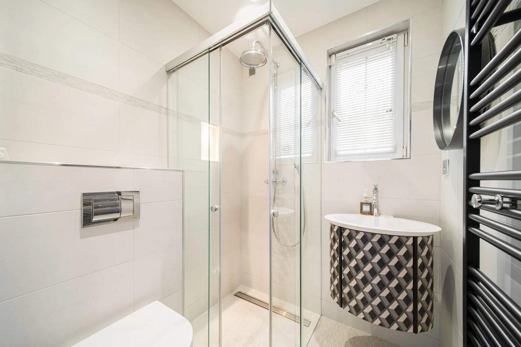 Bright private bathroom with a glass shower enclosure