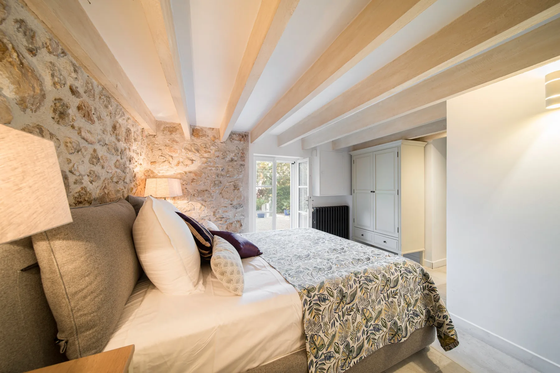 Bedroom 3 with exposed stone wall and timber beams